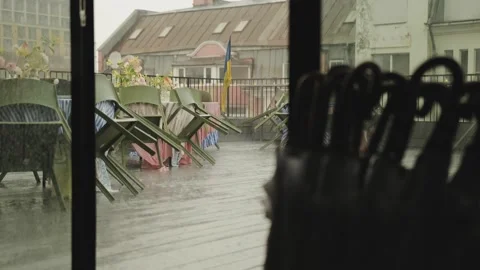 View through sliding doors of a cafe terrace during the rain. Empty wet tables Stock Footage 318065135