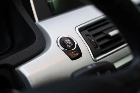 View through steering wheel on start and stop engine button in deluxe car Foto stock