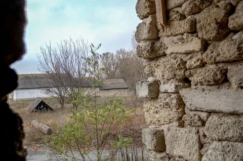 View through stone wall opening to rural village houses Stock Photos