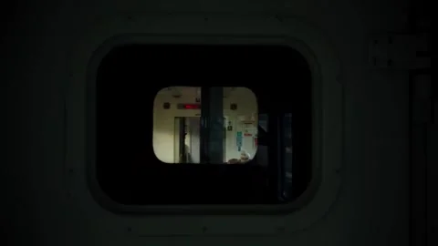 View through train window shows passengers in adjacent carriage during journey Stock Footage 340863337