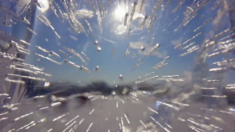 View through transparent crystal thick ice on sun at blue sky, sunlight rays Stock Footage 165147426
