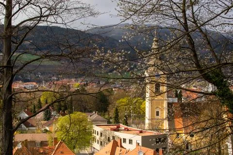 View through the tree branches of a Christian church in a small Austrian town Stock Photos