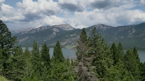 View through the Trees to a Lake and Mountains Stock Footage 266287515