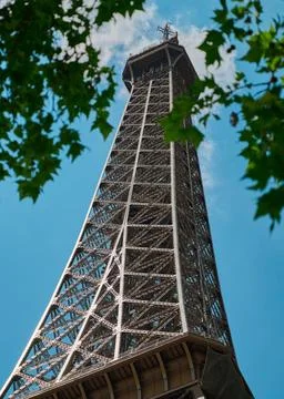 A view through the trees looking up at the top of the eiffel tower Stock-Fotos
