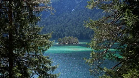 View through trees of a mountain lake. Zugspitze Eibsee Stock Footage 88795075