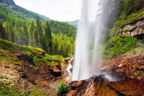 View through a waterfall into a valley with forests and mountains - johanne.. Stock-Fotos