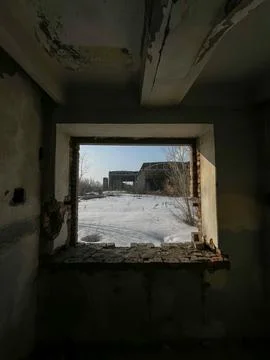 A View Through a Weathered Window Frame in an Abandoned Building Showcasing.. Stock Photos