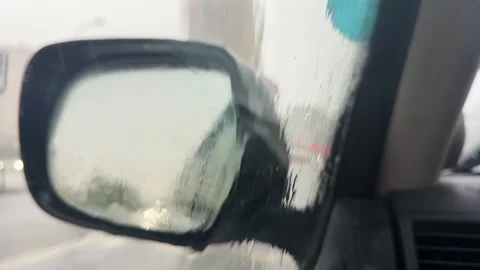 View through wet car window on side mirror Vídeos de archivo 346164589