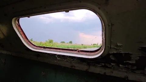 View Through Window of Abandoned Trailer at Lake and Storm Sky Stock-Footage 339589570
