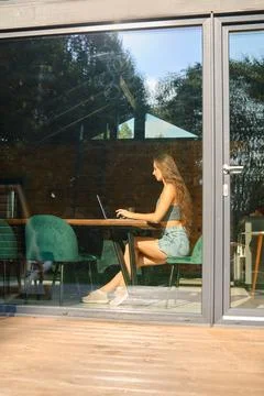 A view through the window of a blogger writing a post about her vacation ex.. 库存照片