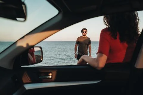 View Through Window of the Car, Man Standing in Front of Curly Woman in Red Stock Photos
