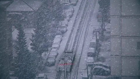 View through window to the city streets and tank riding in snow falling. Video stock 171700111