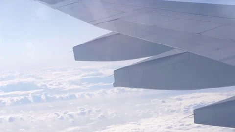 View through window of commercial jet air plane with wing flying over clouds Stock Footage 82093392