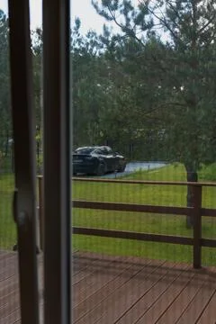 View Through a Window of a Countryside Yard with a Black Tesla Car Stock Photos