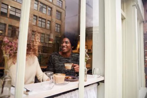 View Through Window Of Couple Enjoying Drink In Coffee Shop Stock Photos