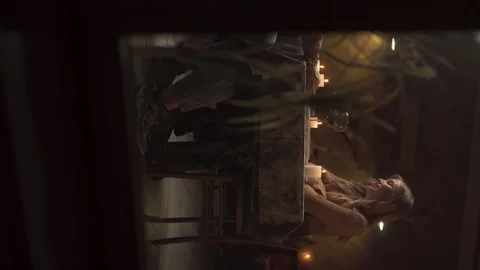 View through the window of a couple in love having dinner at home or in a cafe Stock Footage 255103756