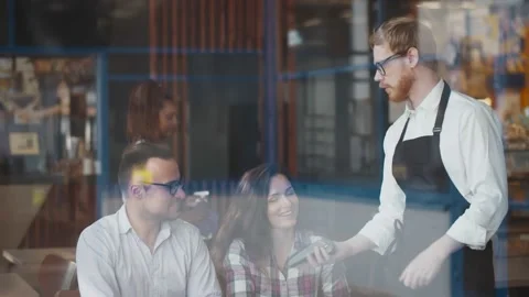 View through window cute couple on date at cafe paying by credit card Stock Footage 134540207