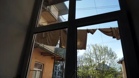 View through the window dark room at laundry hanging on clotheslines Stock Footage 272983767