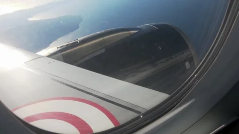 View through a window of an engine and wing, cruising over the coast. Stock Footage 345357962