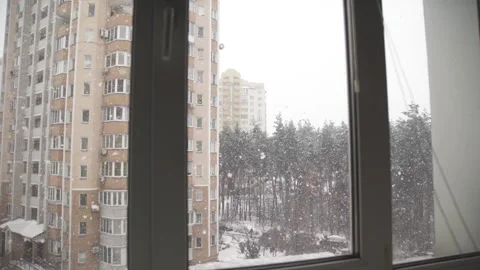 A view through the window of falling snow in winter Video stock 329227322