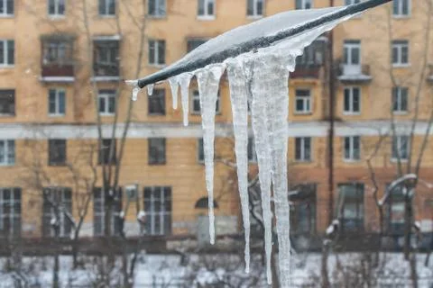 View through a window with a group of sharp bright white transparent icicles Stock Photos