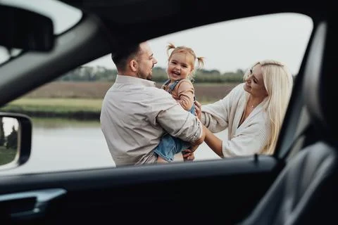 View Through Window Inside of Car, Happy Young Family, Mom and Dad with Their Stock Photos
