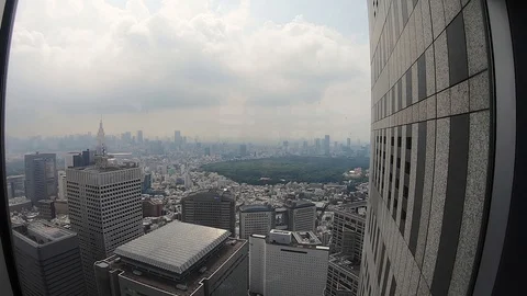 View through window looking over Tokyo city skyline from Shinjuku, 100fps. Video stock 128784411