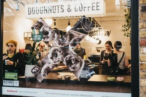 View through the window of people inside Crosstown doughnuts and coffee cafe  Stock Photos