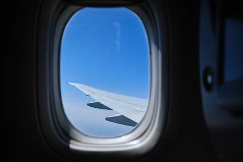 View through the window of the plane on Airplane wing on the blue sky Version2 Stock Photos