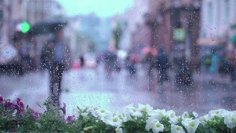 View through the window on rainy day. Raindrops on window glass, people walk on Stock-Footage 78086072