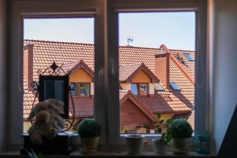 View through a window onto traditional red tiled rooftops of charming Europ.. Stock Photos