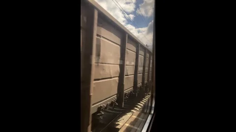 View through the window of a train carriage at oncoming freight cars Stock Footage 304670281