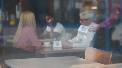 View through window of waiter putting sign with qr code for discount or Stock Footage 135225578
