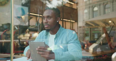View through the window where good-looking thoughtful busy young black-skinned Stock Footage 141532242