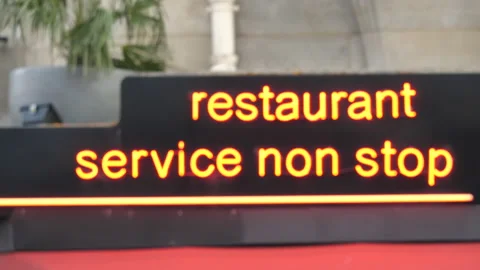 View through the windows of bus at Restaurant service non stop neon signage in Stock Footage 149327474