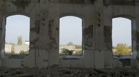 View through the windows from ruined old building on abandoned yard, pan right. Stock Footage 57392330
