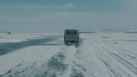 View through the windshield of a car on a convoy of UAZ minibuses on the icy Stock-Footage 154581574