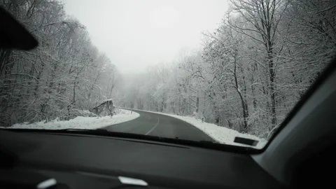 View through the windshield of a car driving down the winter snowy road. Stock Footage 232978399