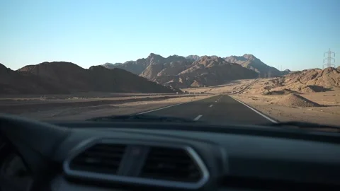 View through windshield of the car driving by the asphalt road in the desert at Stock Footage 251887957