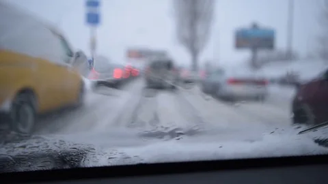 View through windshield on defocused scene on snowy city road Stock Footage 77415286