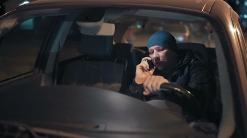 View through the windshield man talking on the phone sitting behind the wheel of Stock Footage 98471041