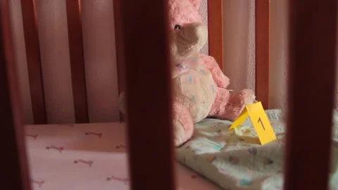 View through the wooden ledge of a crib that is evidence of a baby kidnapping Stock Footage 139138138