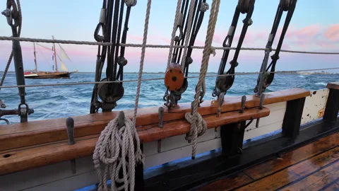 View through wooden ship rigging at rough sea waves and distant sailboat. Stock Footage 342079068
