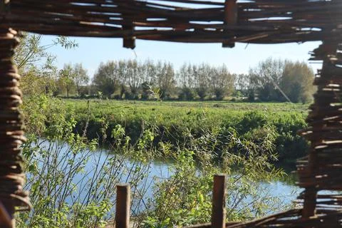 A view through the woven willow screen over the River Parrett in Langport in  Stock Photos