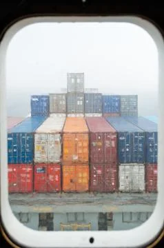 View throught the porthole of a container ship Stock Photos