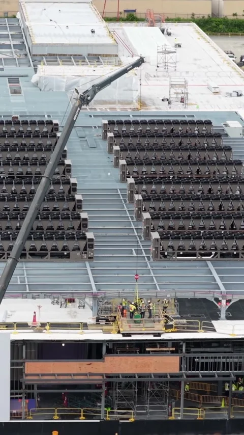 The view tilts up a crane boom from a finished data center roof deck in Stock Footage 345728514