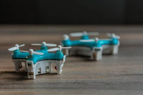 View of tiny drone on a wooden background. Small blue drone with white propel Foto stock