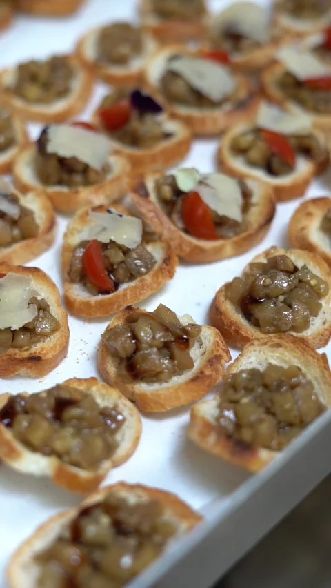 View of toasted bread bites topped with a creamy mushroom mixture and a garnish Stock Footage 321671568