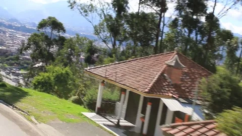 The view on top of a bus while driving down a steep hill with a cityscape Stock Footage 107685168