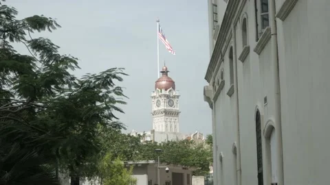 View to the top of the clock tower with malaysia flag in summer daytime in .. Stock Footage 238887437